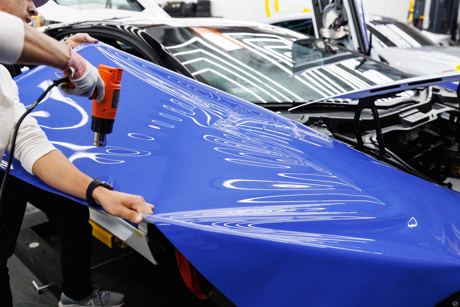 車のボディへラッピングフィルムを施工する様子